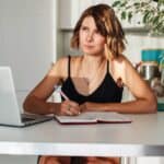 young woman writing an obituary