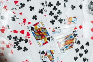 Colorful assortment of playing cards laid out in a chaotic pattern, showcasing various suits and face cards.